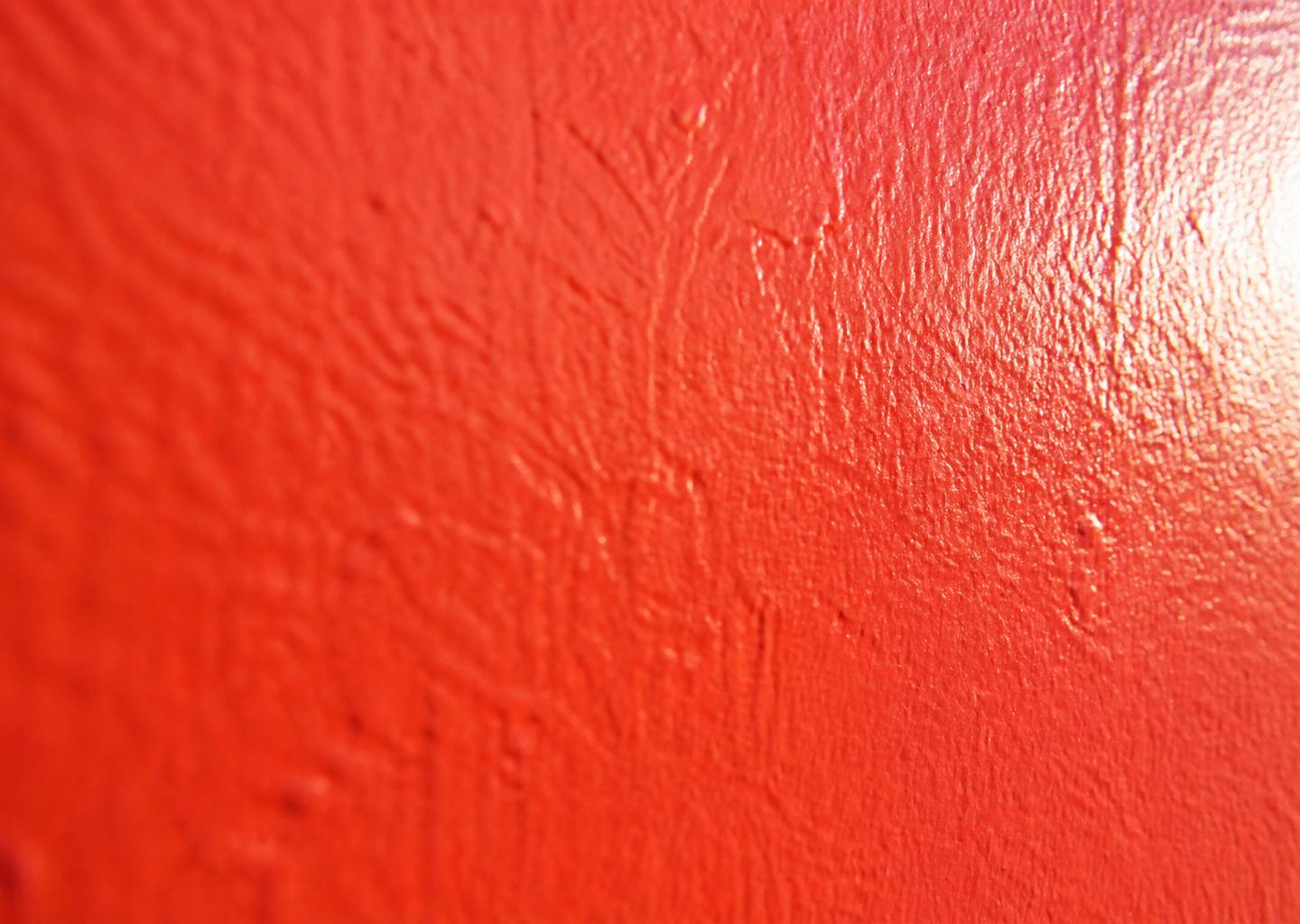 Close-up of a first brush stroke of colour going onto a plain white wall